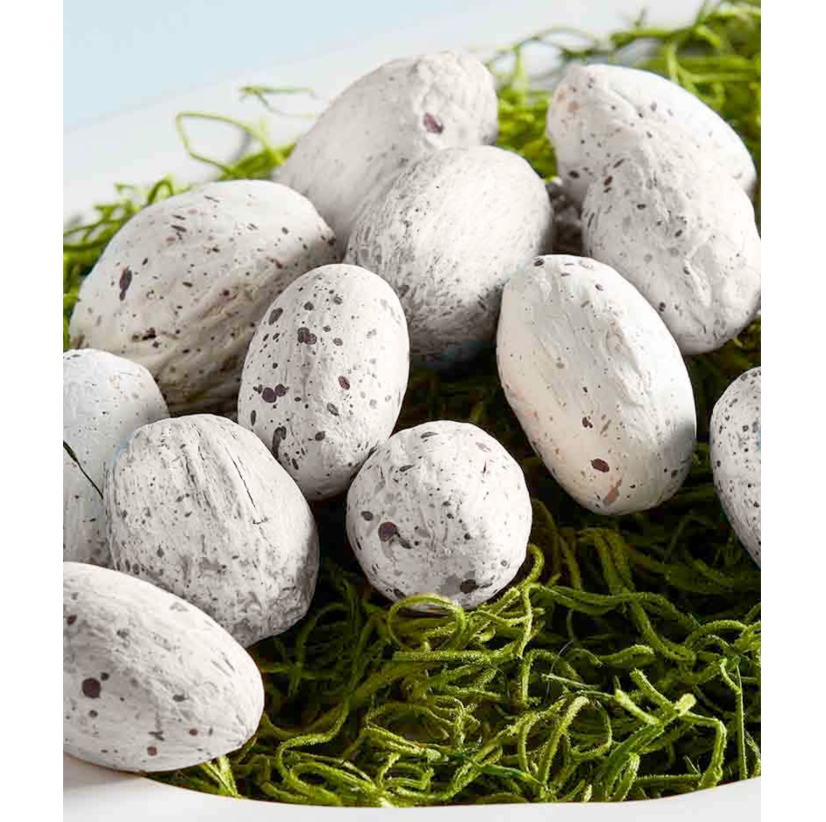 White speckled eggs on a bed of green grass