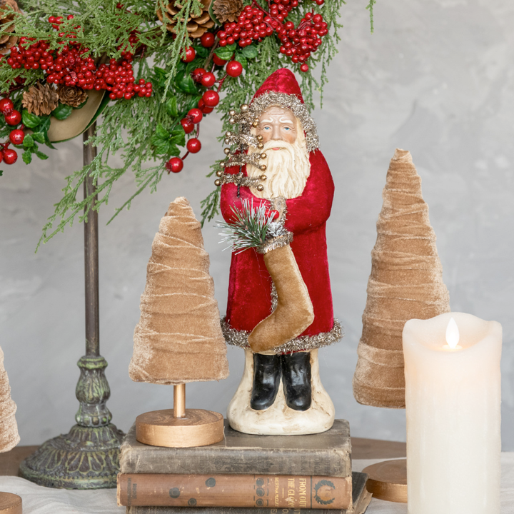 Decorative Christmas scene with Santa Claus figure, candles, and festive elements on a gray background