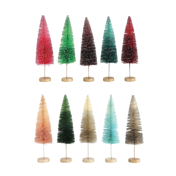 Set of seven colorful Christmas trees on stands against a white background
